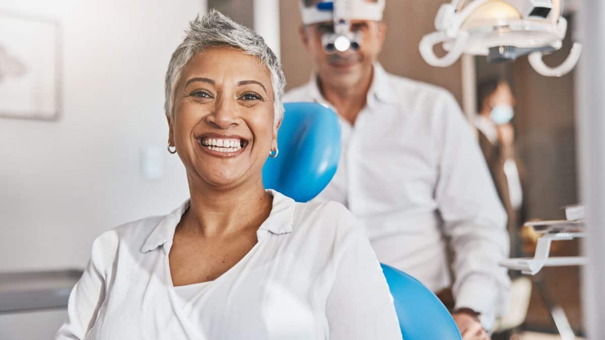 Portrait, happy and dental with a woman patient in a doctor office for oral hygiene or health. Smile, teeth and healthcare with a senior female sitting in a chair at the dentist for hygiene
