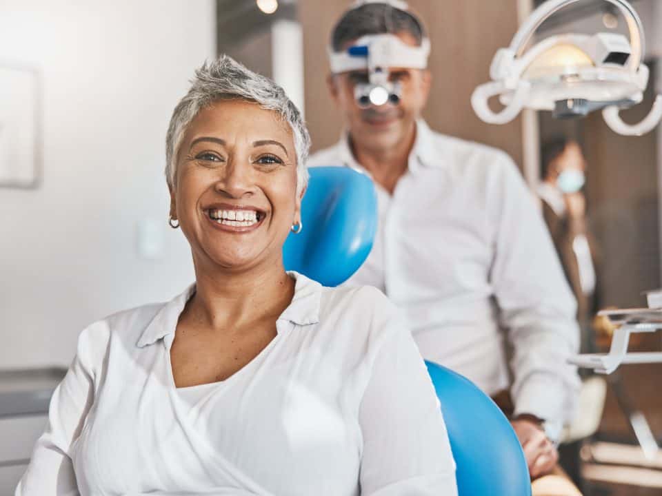 Portrait, happy and dental with a woman patient in a doctor office for oral hygiene or health. Smile, teeth and healthcare with a senior female sitting in a chair at the dentist for hygiene